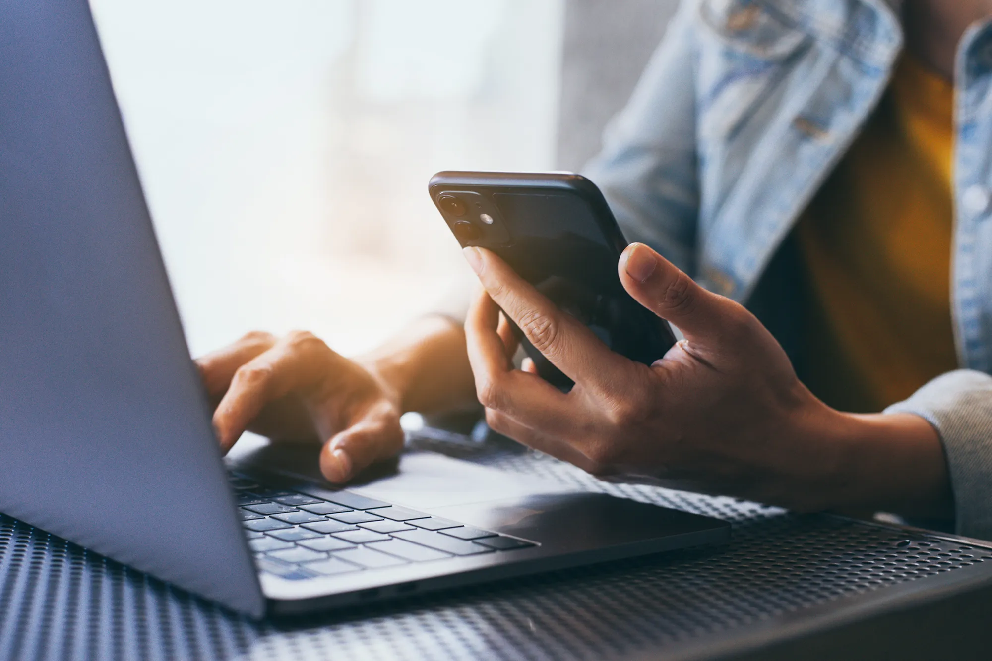 Iemand die een mobiele telefoon vasthoudt om contact te leggen.
